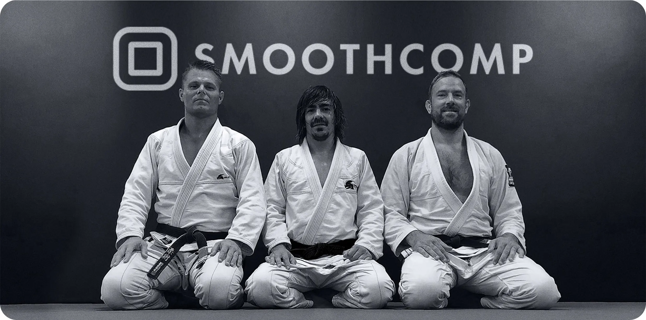 The Smoothcomp founders in front of the Smoothcomp logo