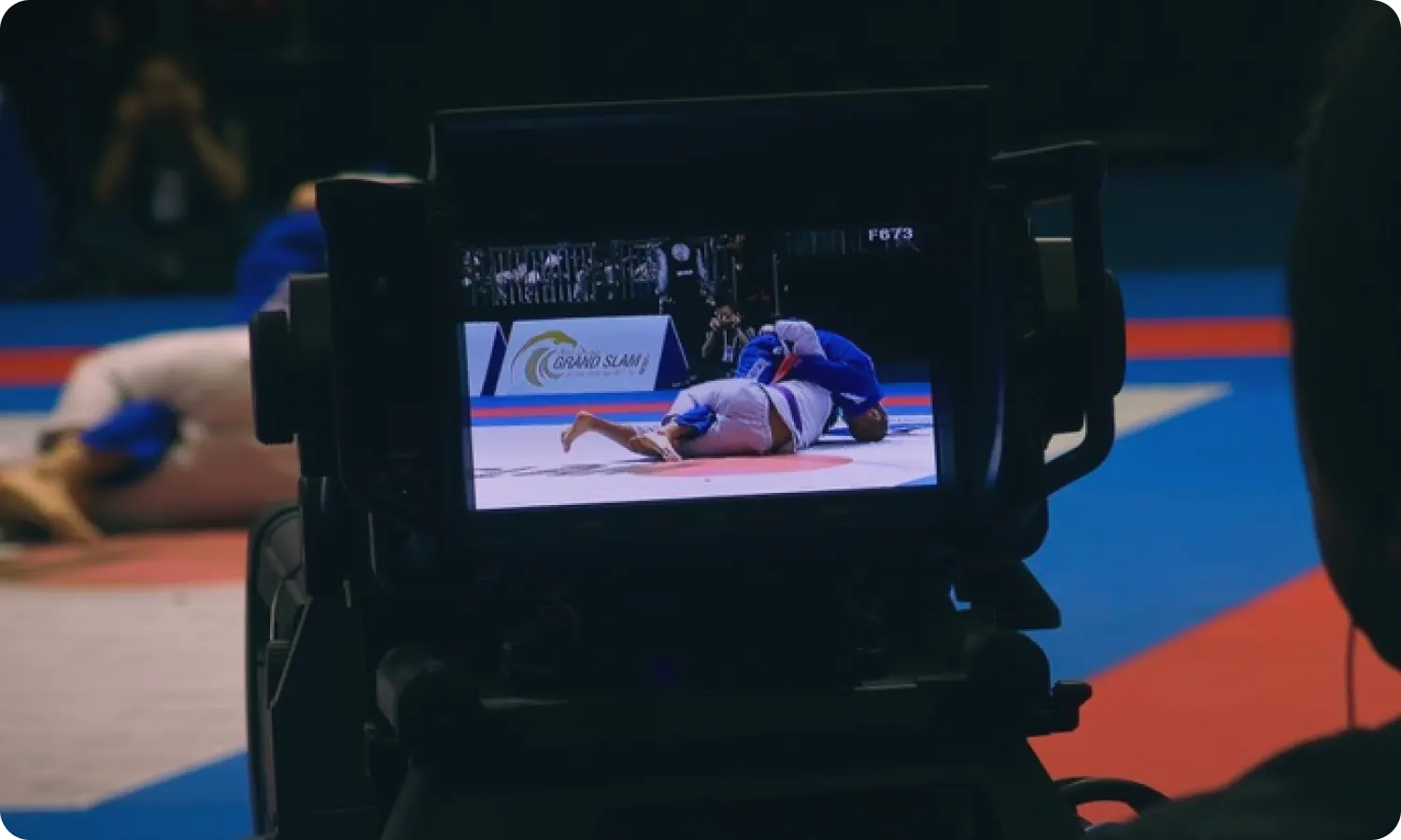 A broadcast camera filming a judo match