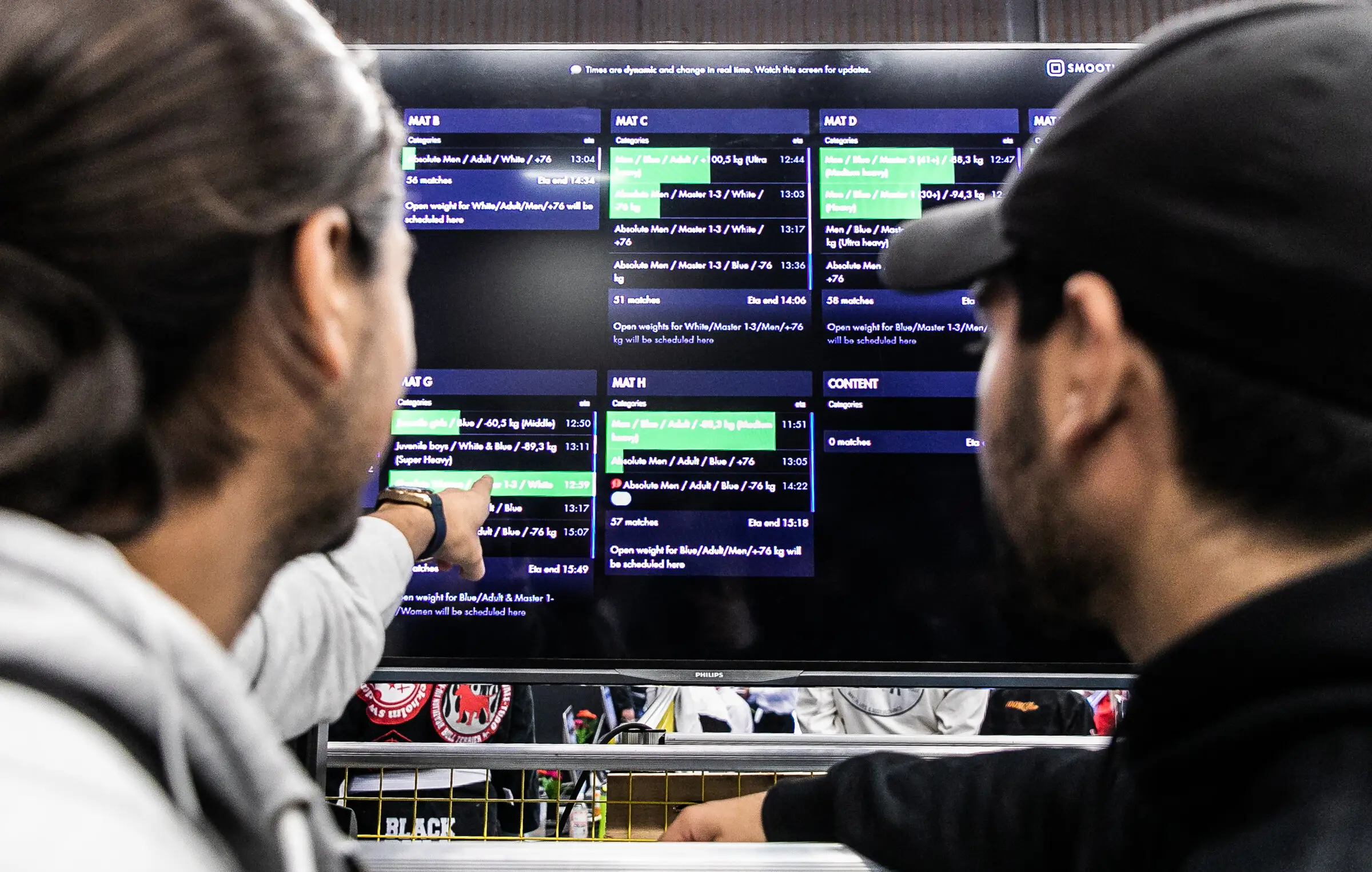 Tournament staff checking the live schedule on a large screen